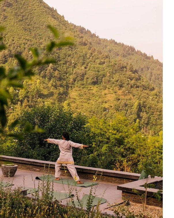 Yoga practice on a terrace facing forested hills